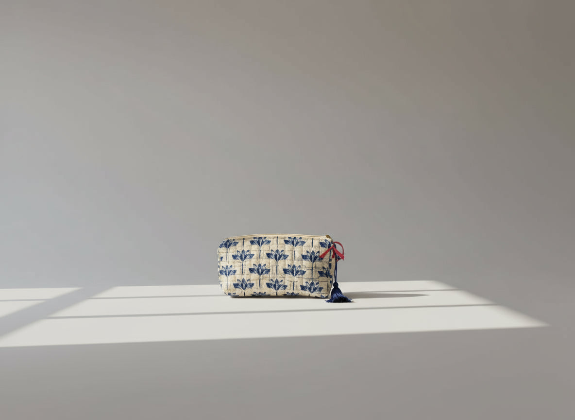 Fabric pouch with blue floral pattern and tassels on a brown background